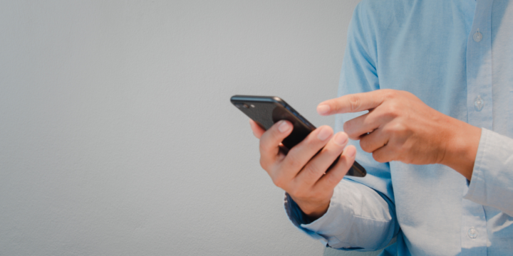 A close up of a man pressing a button on a cell phone.